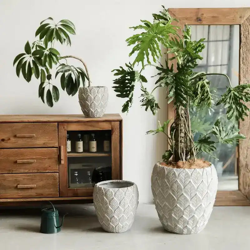 Vases en céramique blanche texturée avec un motif de feuille ou d'écailles décoratif.